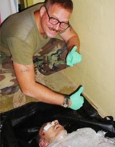 Charles Graner poses over the dead body of an Iraqi prisoner. 